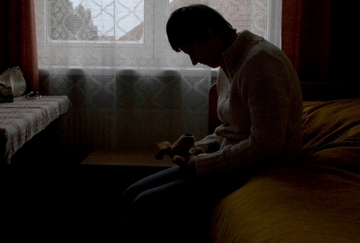 A human trafficking victim sits in a dark room