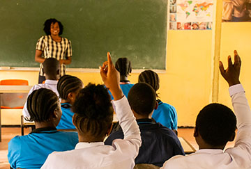 Children answering questions for their teacher in a school room