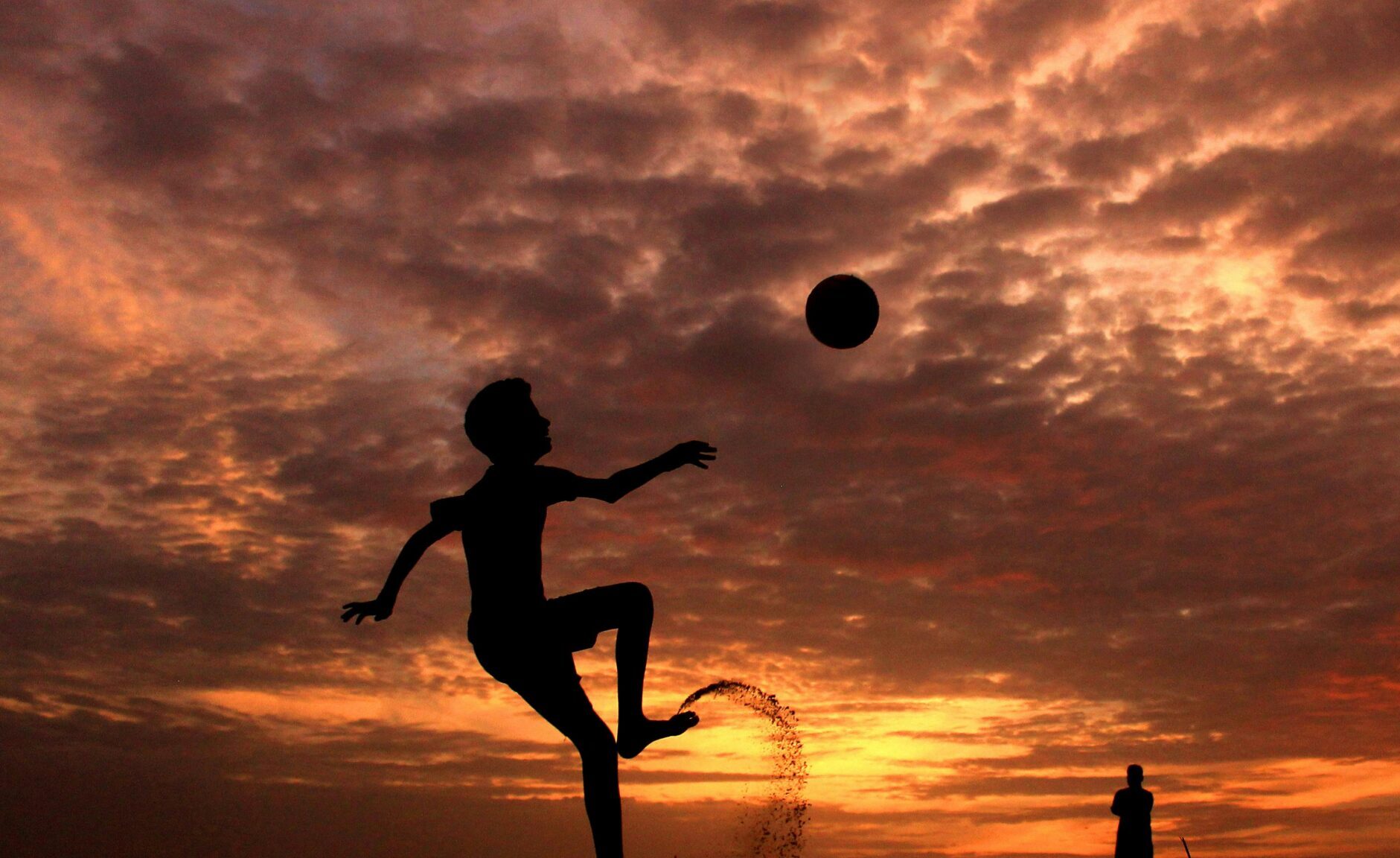 Child playing football in dawn